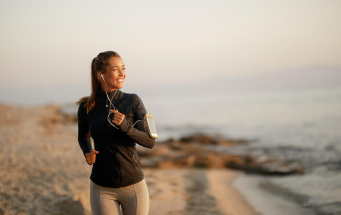 Donna che corre in riva al mare godendo dei benefici della corsa lenta